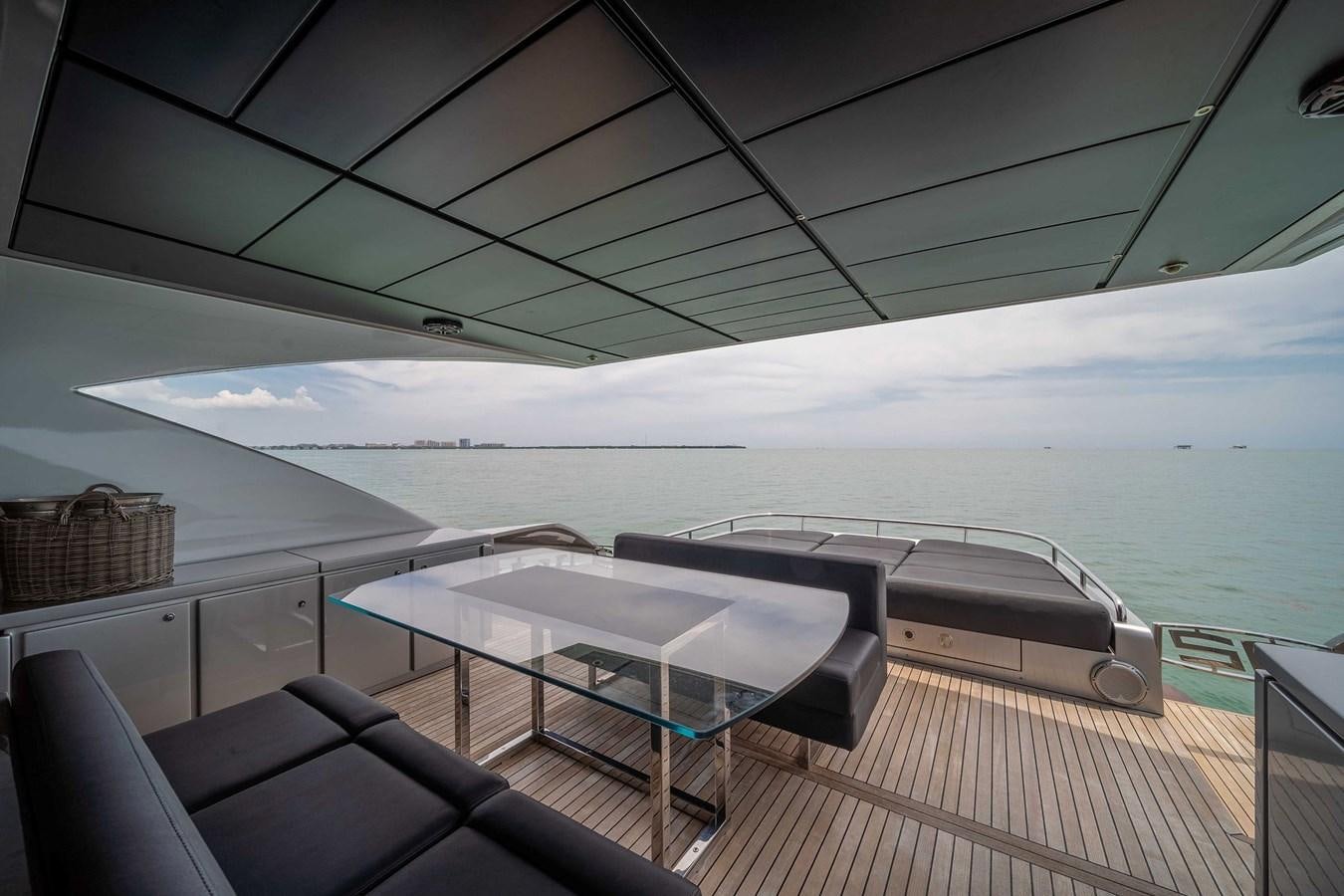 a deck with a table and chairs on it aboard ARENA Yacht for Sale
