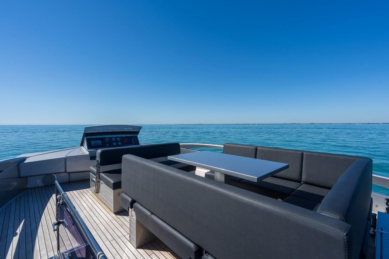 a deck with a boat and a large body of water in the background aboard ARENA Yacht for Sale