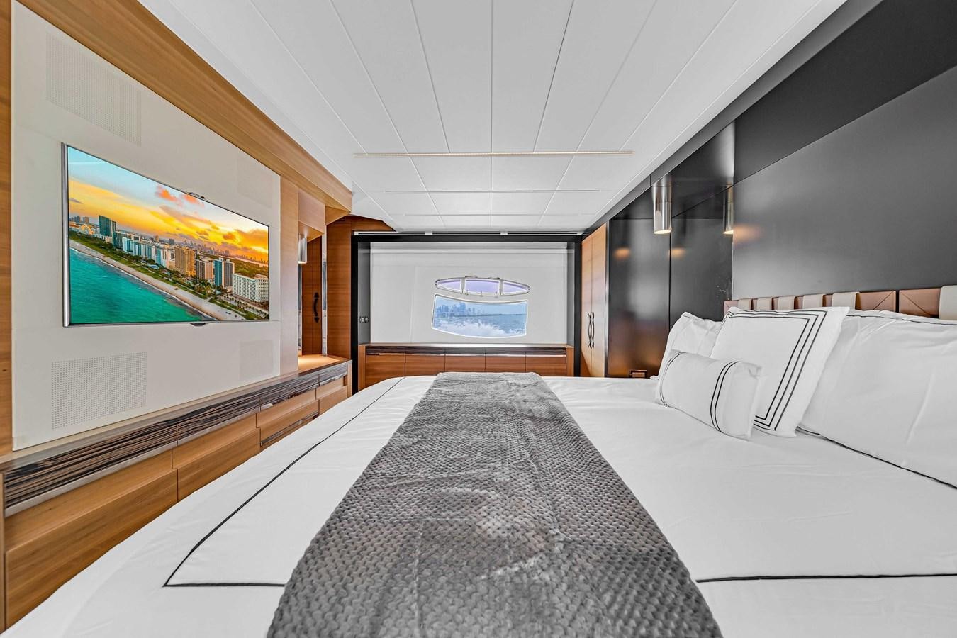 a room with a bed and a tv on the wall aboard ARENA Yacht for Sale