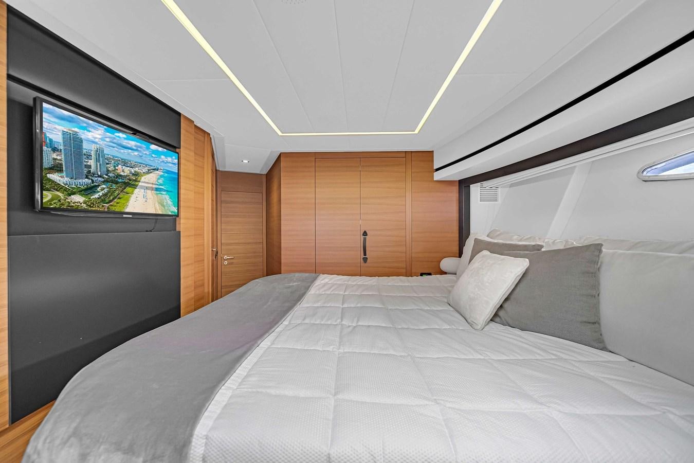 a bed with a television on the wall aboard ARENA Yacht for Sale