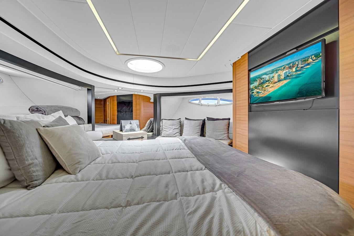 a bed with a television on the wall aboard ARENA Yacht for Sale