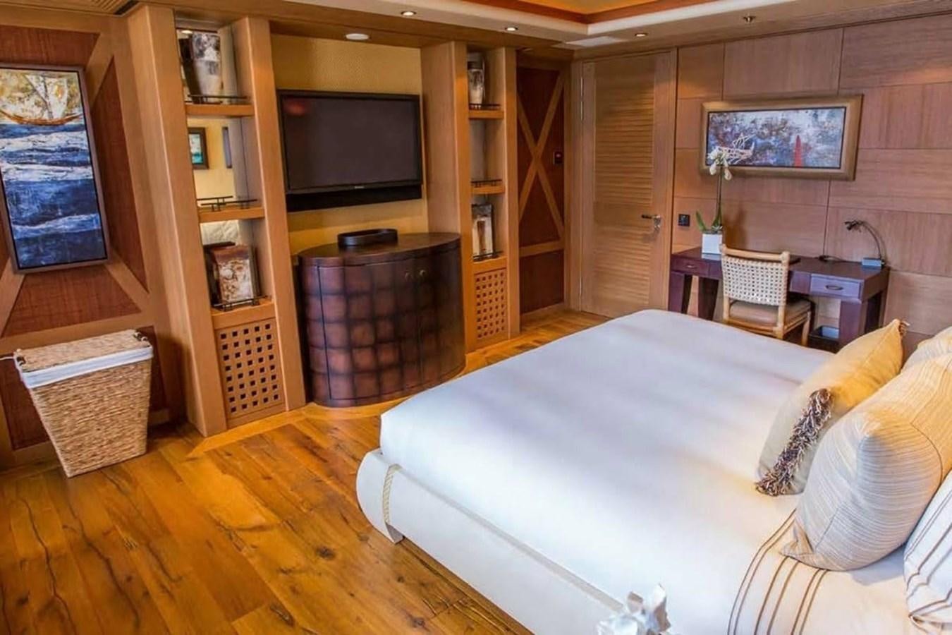 a bedroom with a wood floor aboard PELORUS Yacht for Sale