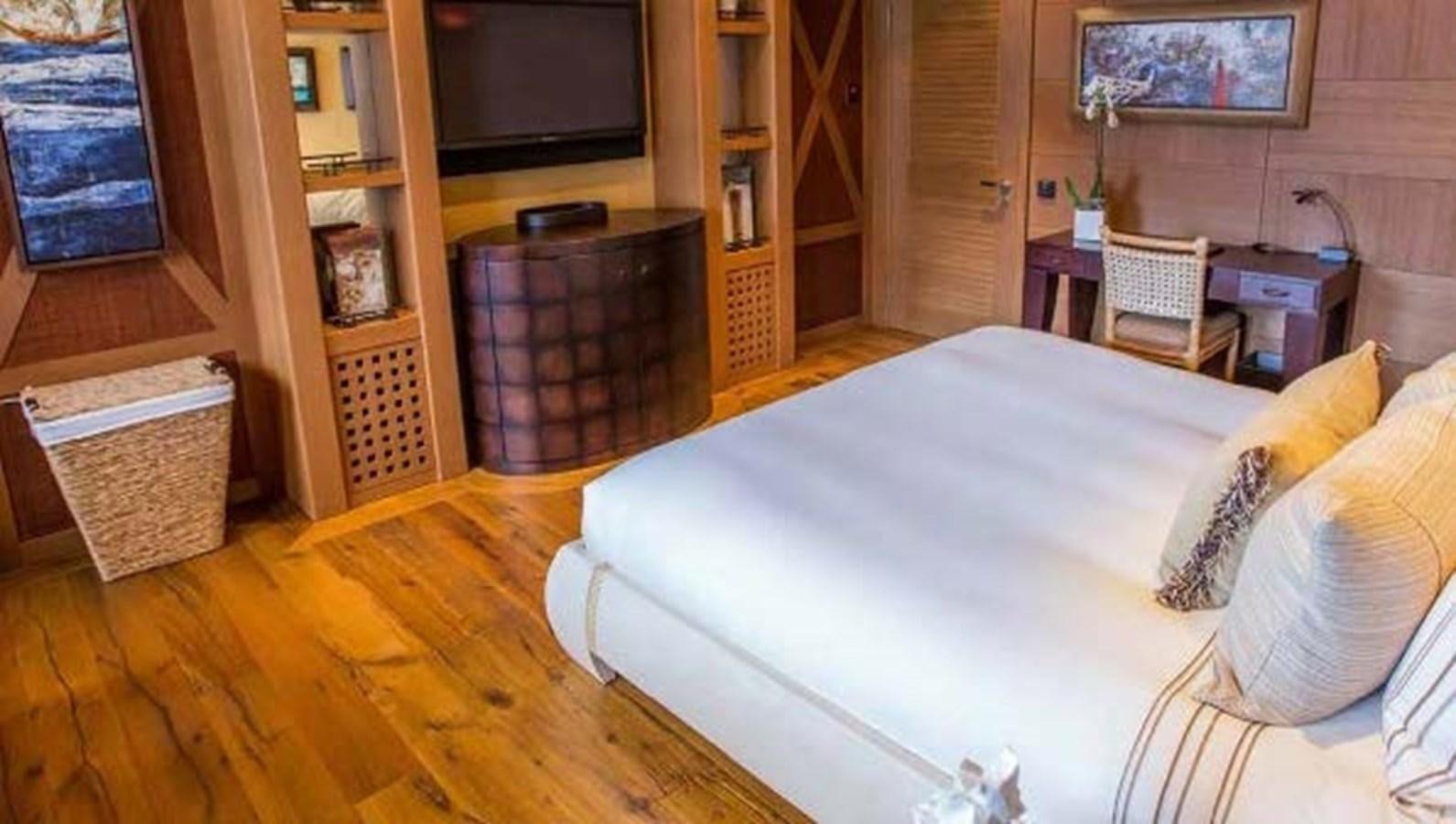 a bedroom with a wood floor aboard PELORUS Yacht for Sale