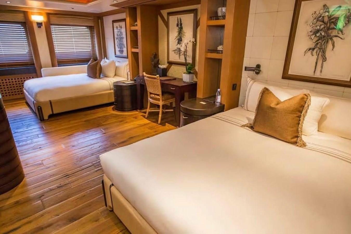 a room with a bed and a table aboard PELORUS Yacht for Sale