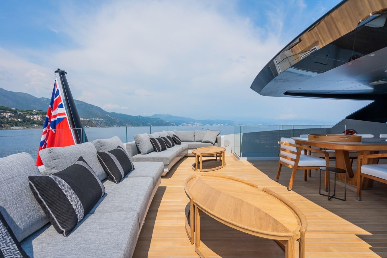 a deck with a table and chairs aboard JIMMY Yacht for Sale