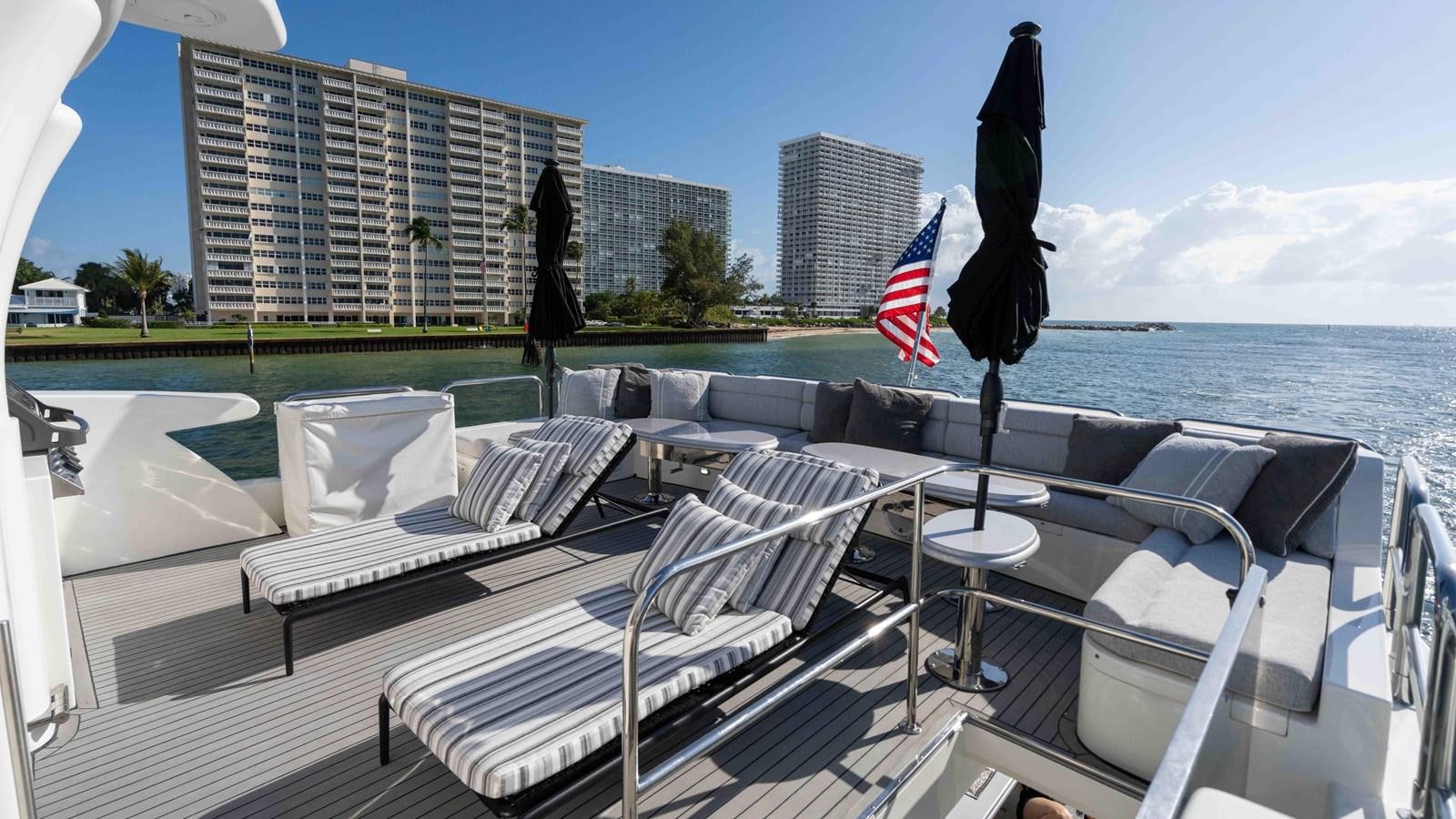 a deck with chairs and a flag on it aboard NEVER SETTLE Yacht for Sale
