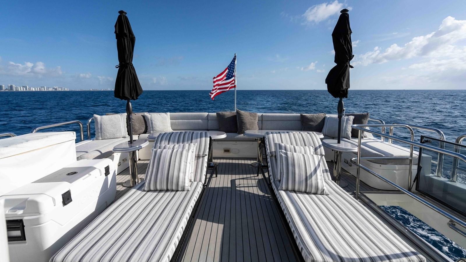 a deck with chairs and umbrellas on it by the water aboard NEVER SETTLE Yacht for Sale