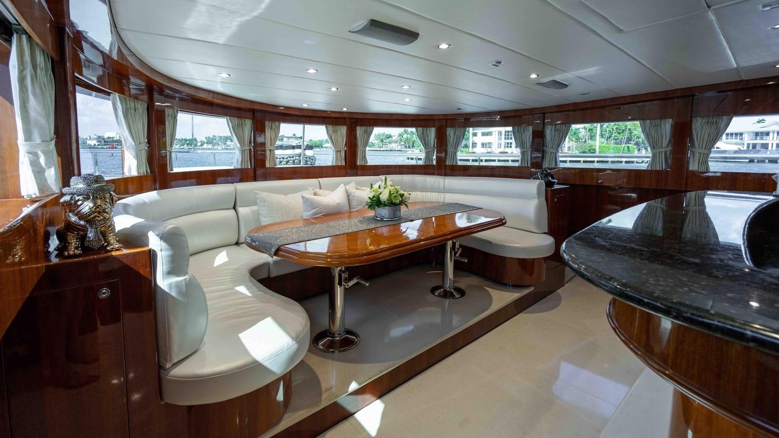 a room with a table and couches aboard NEVER SETTLE Yacht for Sale