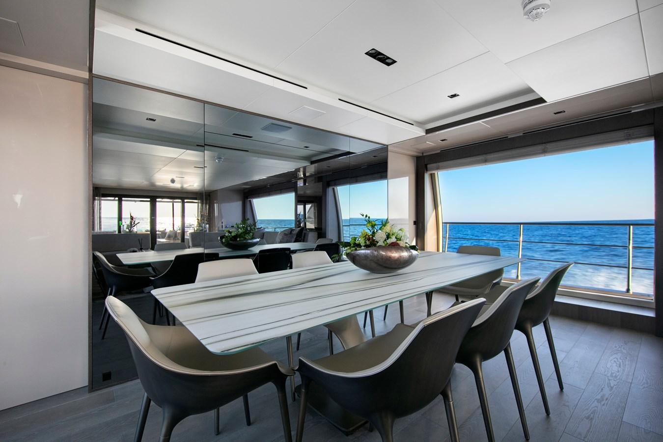 a large room with a table and chairs and a large window aboard CANADOS 122’ CAESAR RPH Yacht for Sale