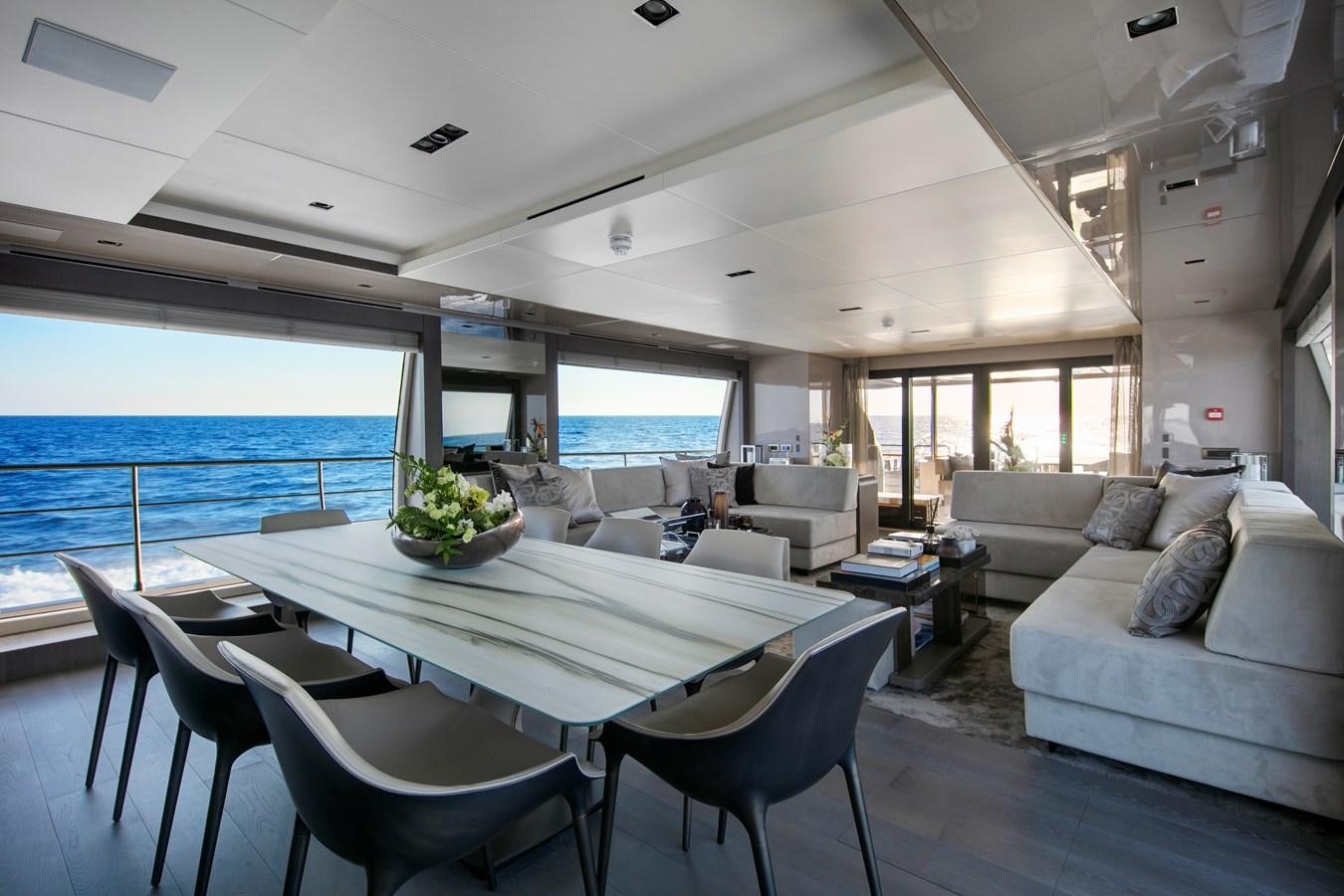 a living room with a large table and chairs aboard CANADOS 122’ CAESAR RPH Yacht for Sale