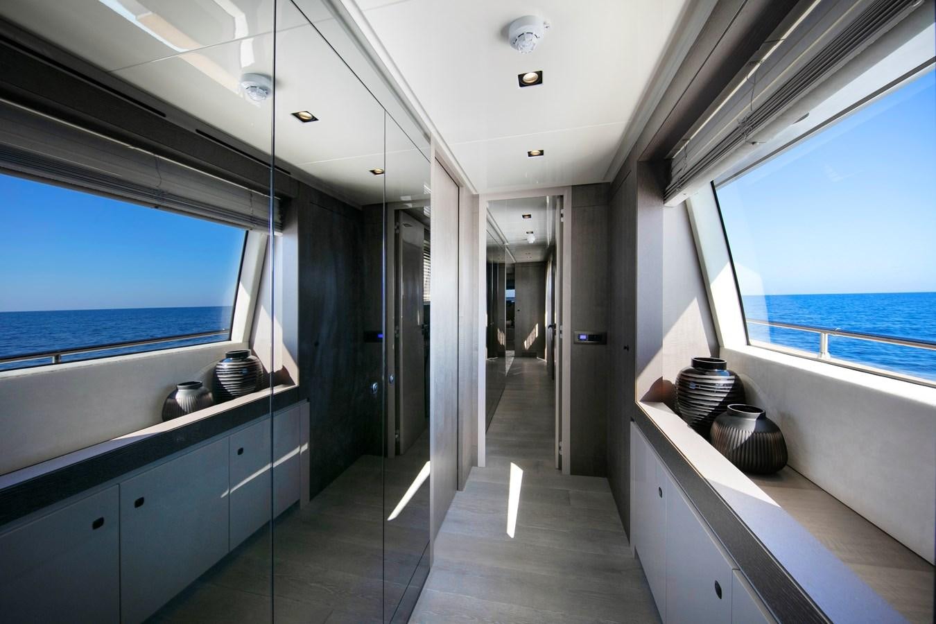 a long hallway with a window aboard CANADOS 122’ CAESAR RPH Yacht for Sale