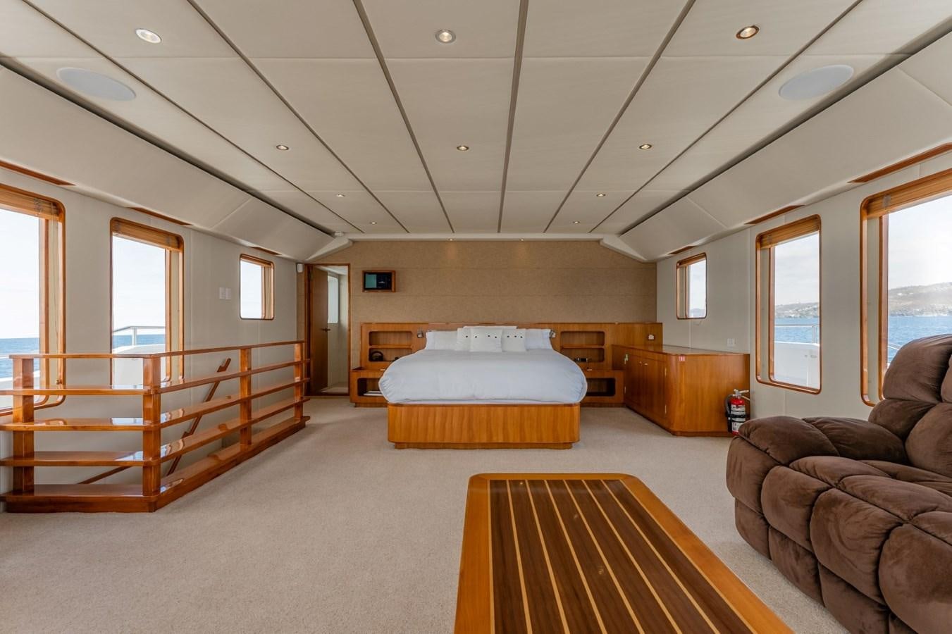 a bedroom with a bed and a chair aboard HARDHOME Yacht for Sale