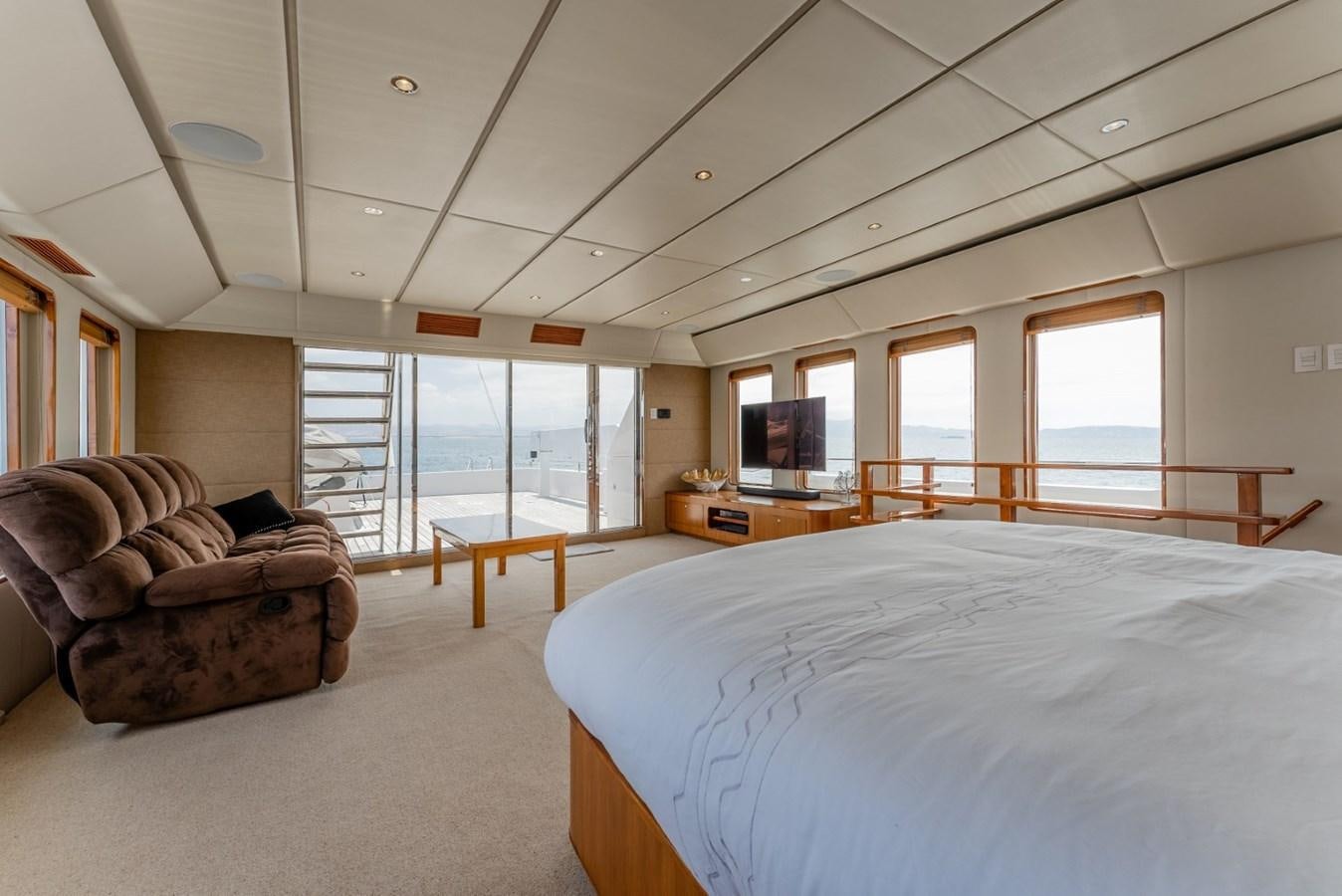 a bedroom with a bed and a couch aboard HARDHOME Yacht for Sale