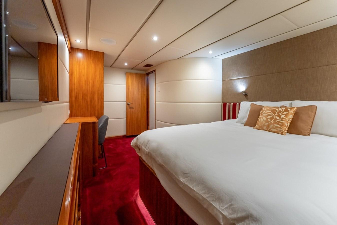 a room with a bed and a chair aboard HARDHOME Yacht for Sale