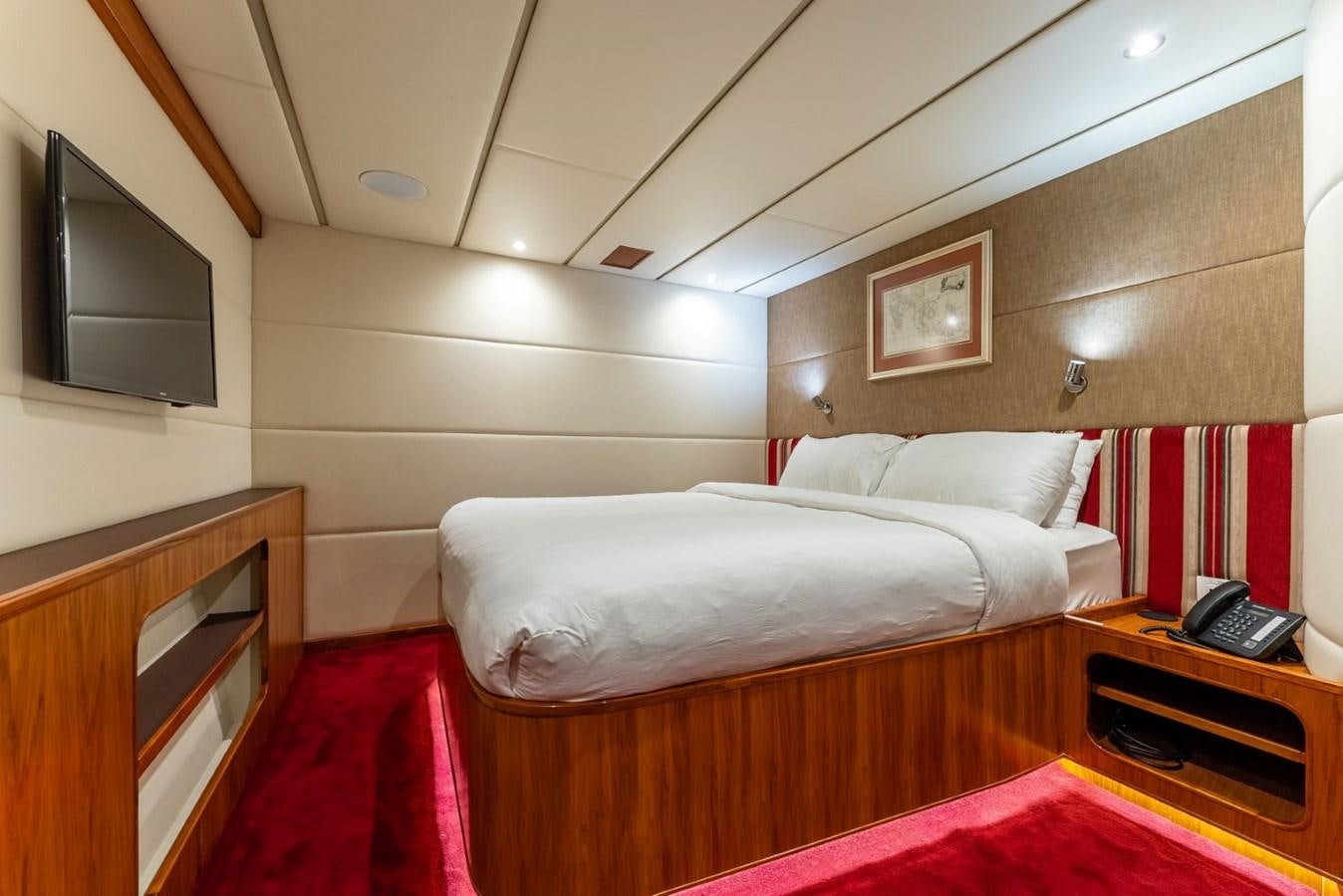 a room with a bed and a tv aboard HARDHOME Yacht for Sale