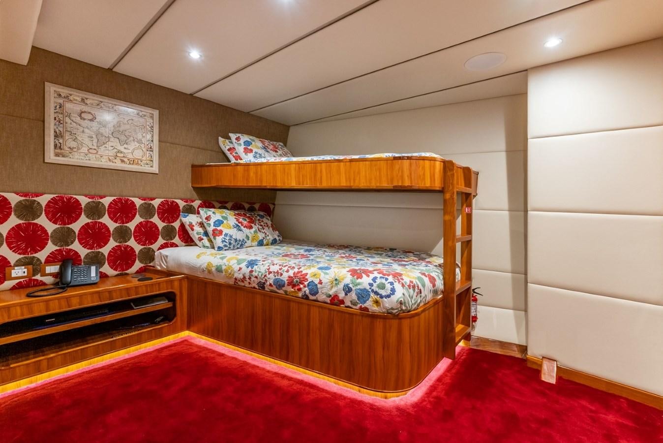 a bed with a colorful comforter aboard HARDHOME Yacht for Sale
