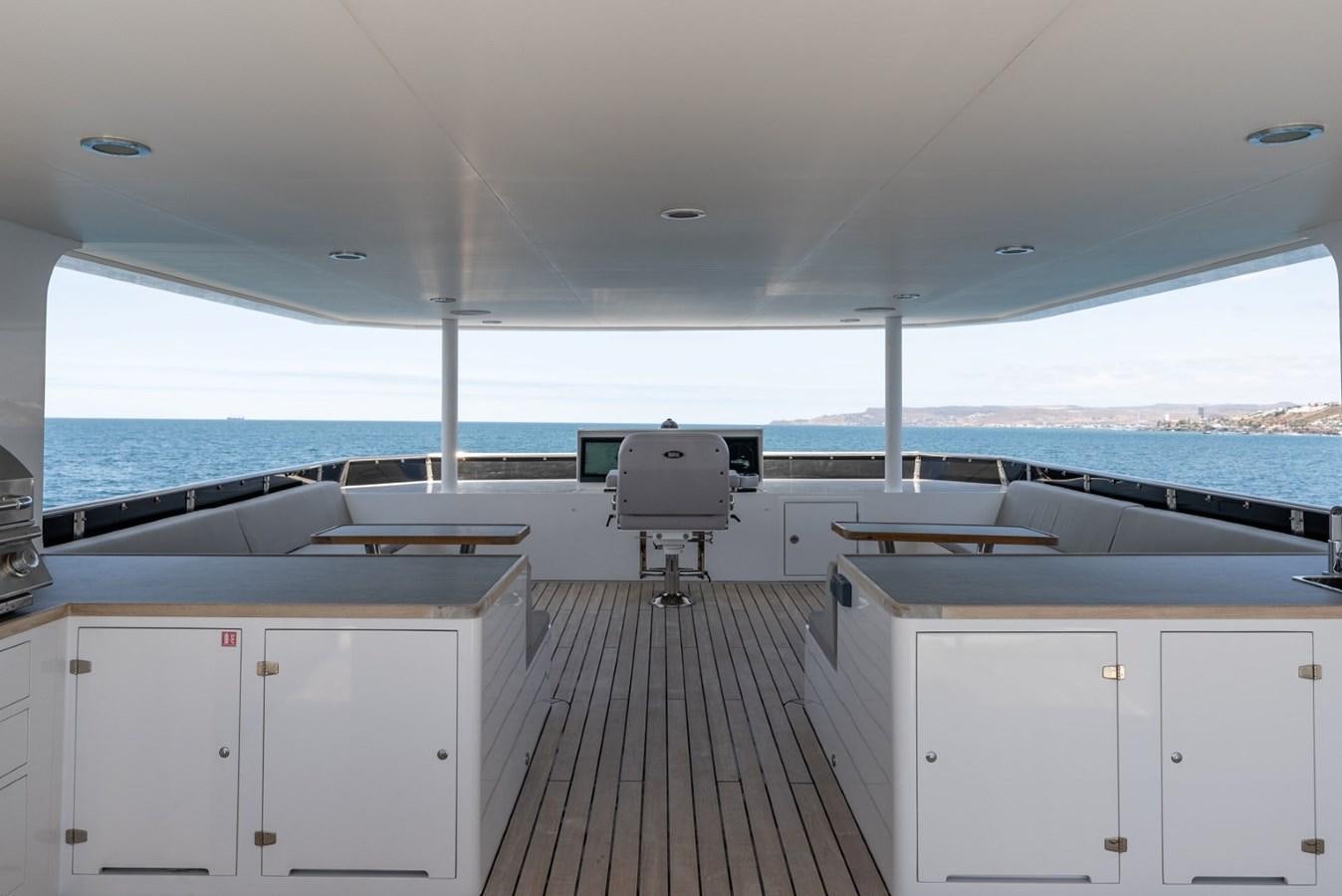 a room with a deck and a view of the water aboard HARDHOME Yacht for Sale