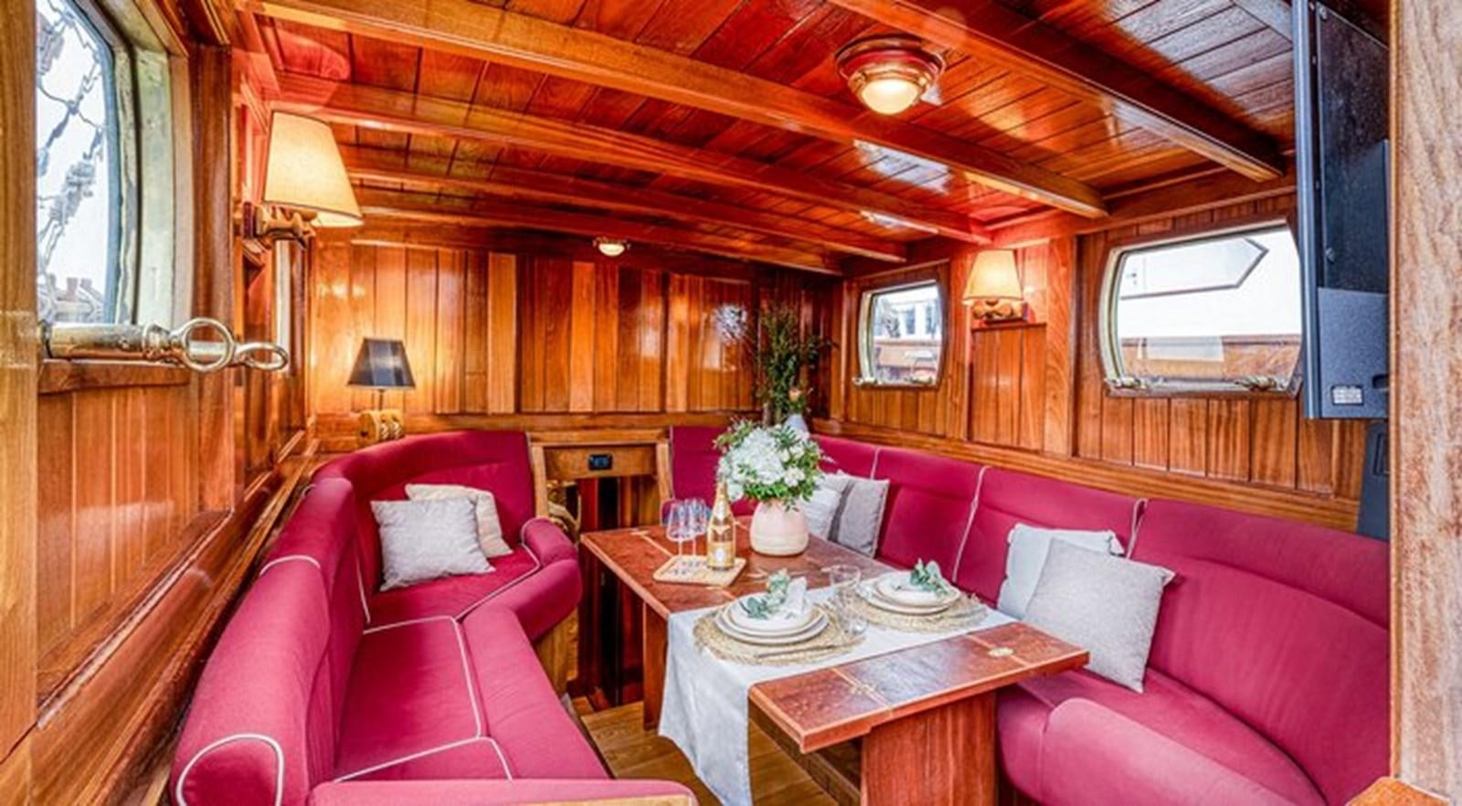 a living room with a red couch and a table aboard O'REMINGTON Yacht for Sale