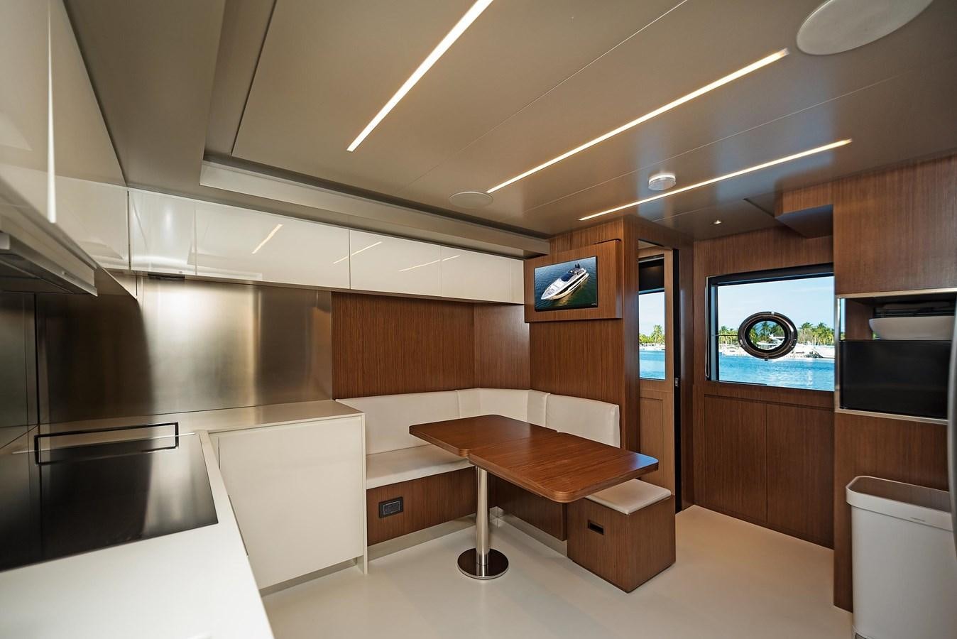 a kitchen with a table and a tv on the wall aboard ALLEGRA Yacht for Sale