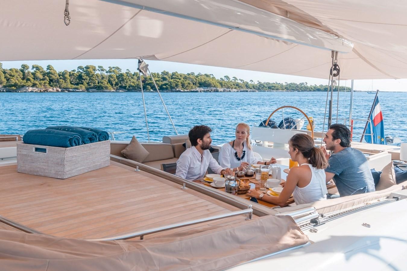 a group of people sitting at a table on a boat aboard GRAND BLEU VINTAGE Yacht for Sale