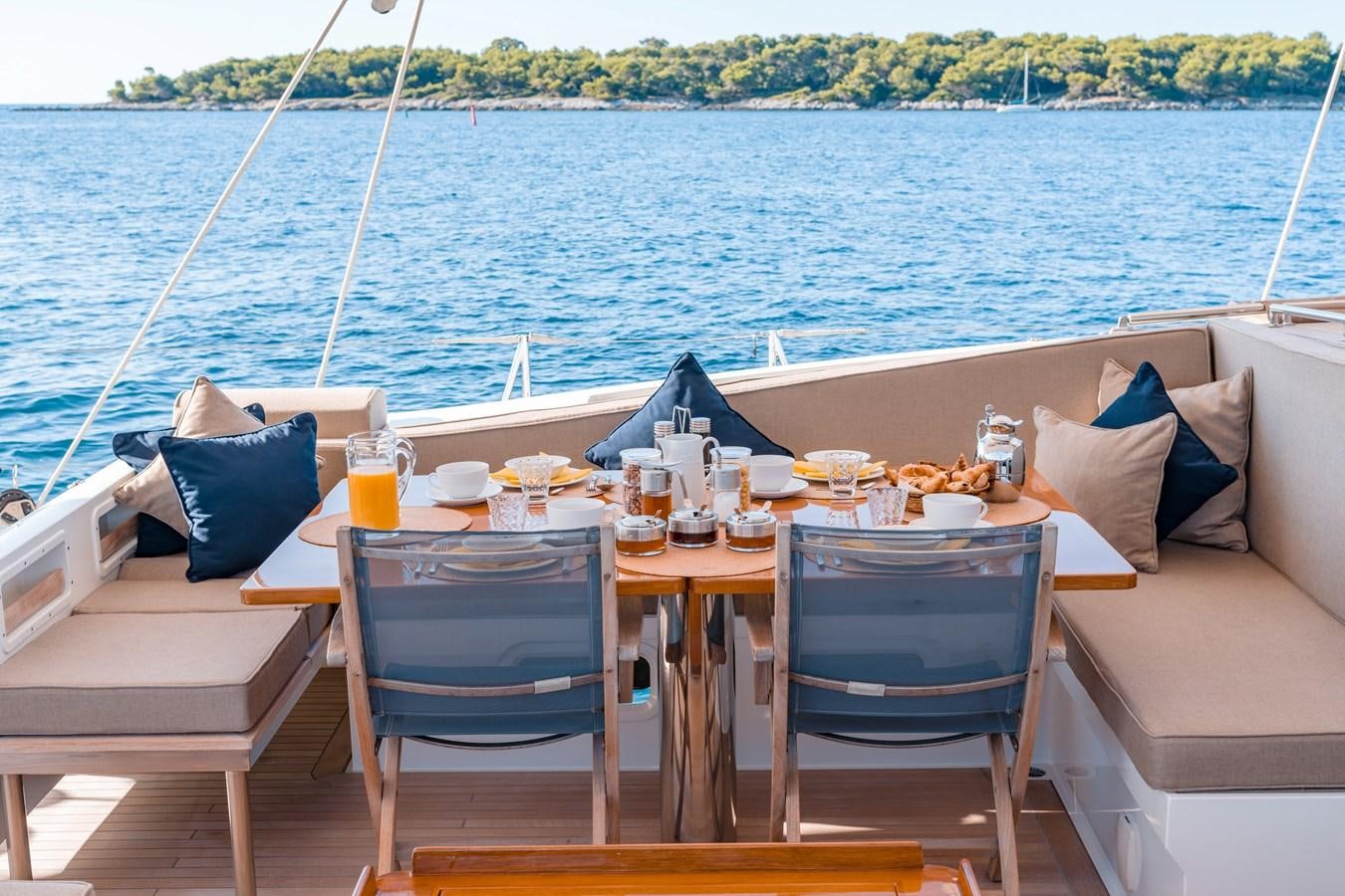 a table set for a meal on a boat aboard GRAND BLEU VINTAGE Yacht for Sale