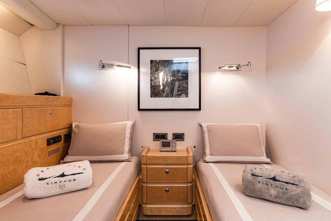 a room with a bed and a dresser aboard GRAND BLEU VINTAGE Yacht for Sale