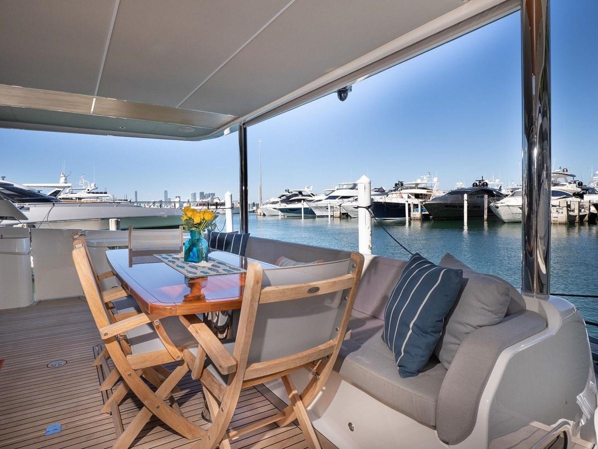 a table and chairs on a deck overlooking a body of water aboard POWERSFUL Yacht for Sale