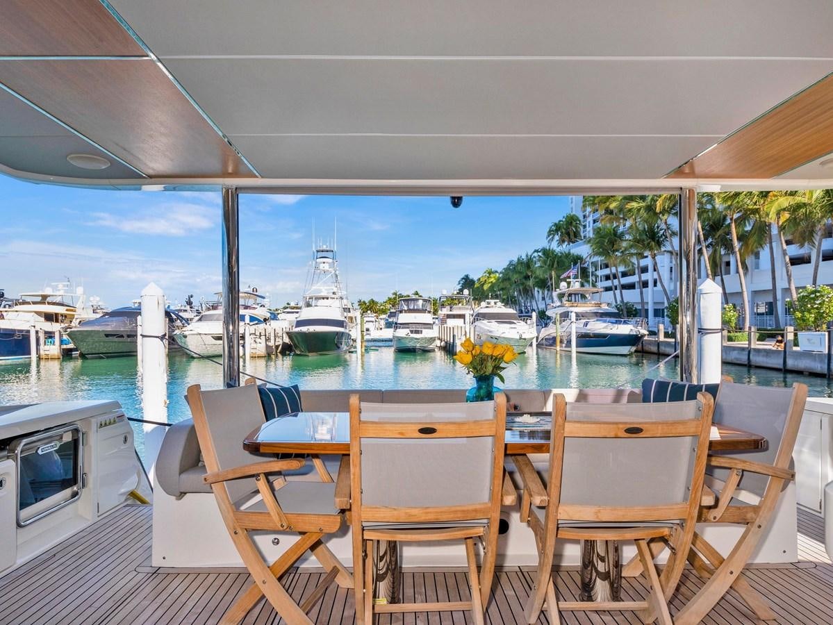 a table and chairs on a deck overlooking a body of water aboard POWERSFUL Yacht for Sale