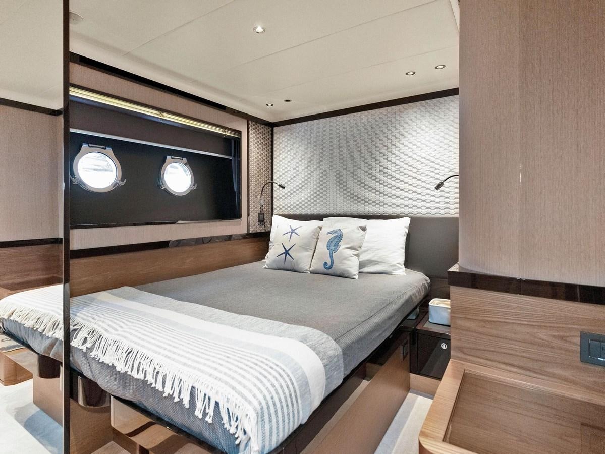 a bed with a black headboard aboard POWERSFUL Yacht for Sale