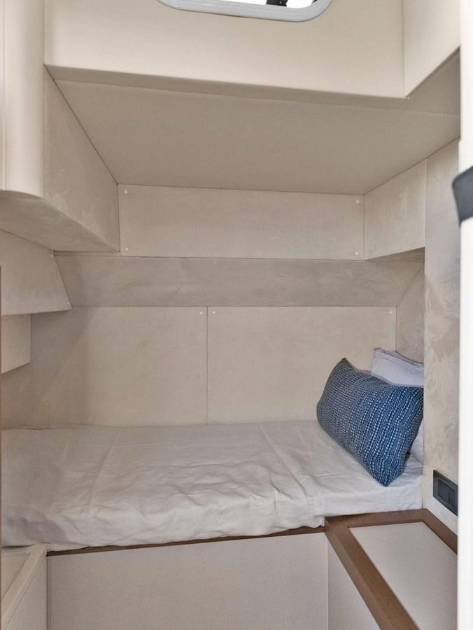 a bed with a white comforter aboard POWERSFUL Yacht for Sale