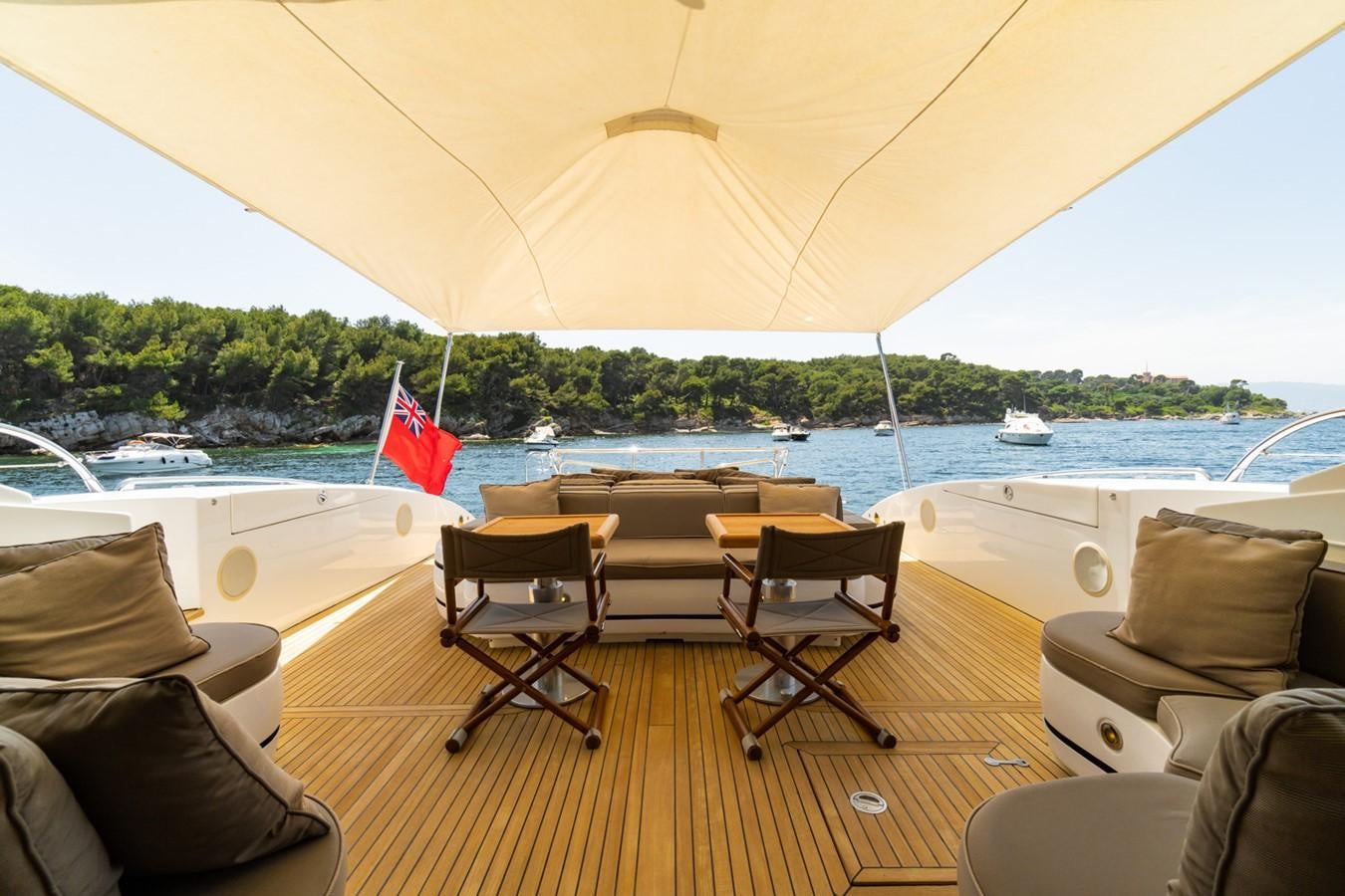 a deck with chairs and a table on it aboard KUY KUY Yacht for Sale