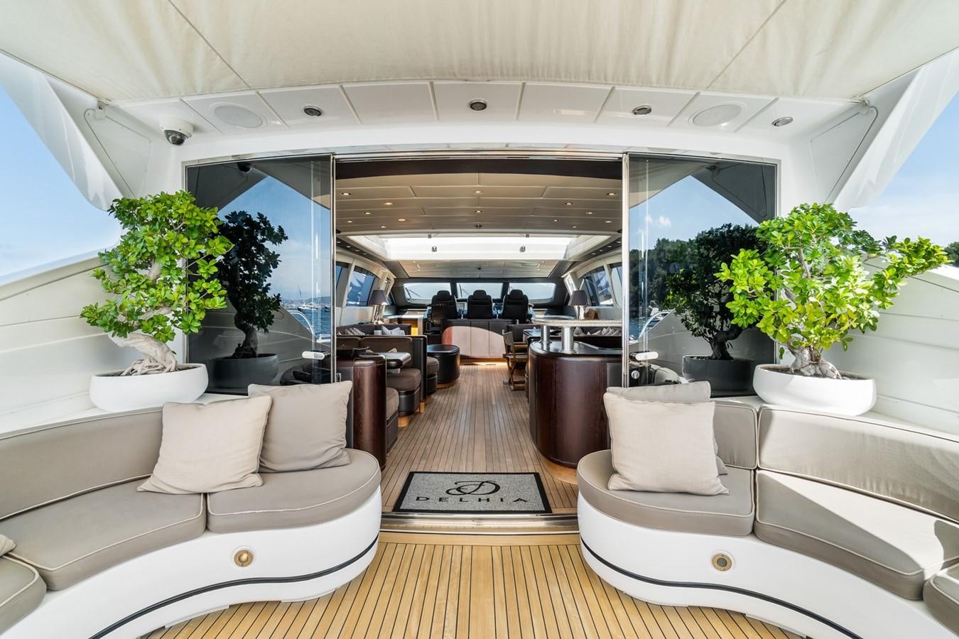 a large room with couches and plants aboard KUY KUY Yacht for Sale