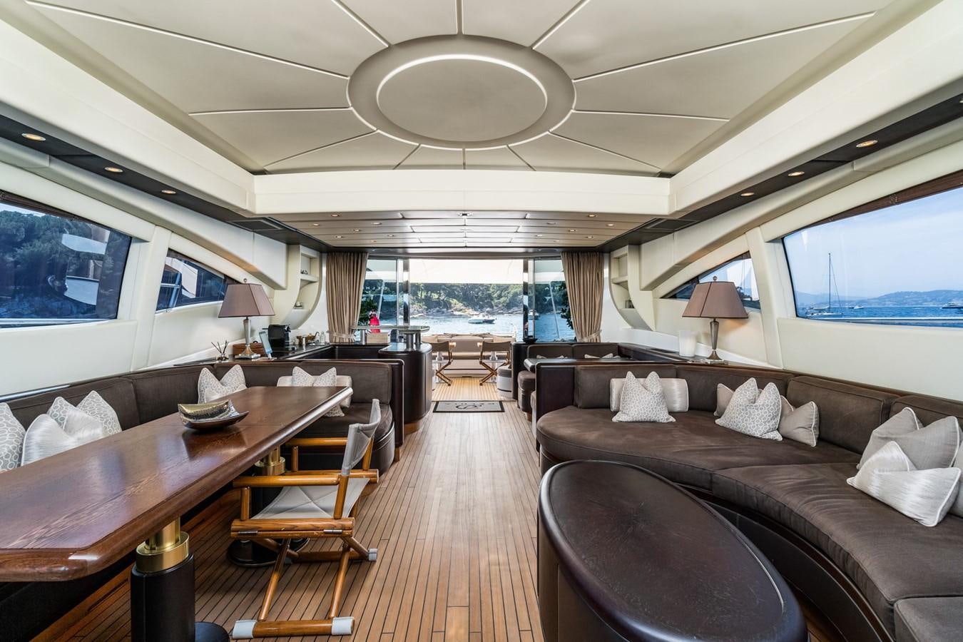 a living room with a wood table and a large window aboard KUY KUY Yacht for Sale