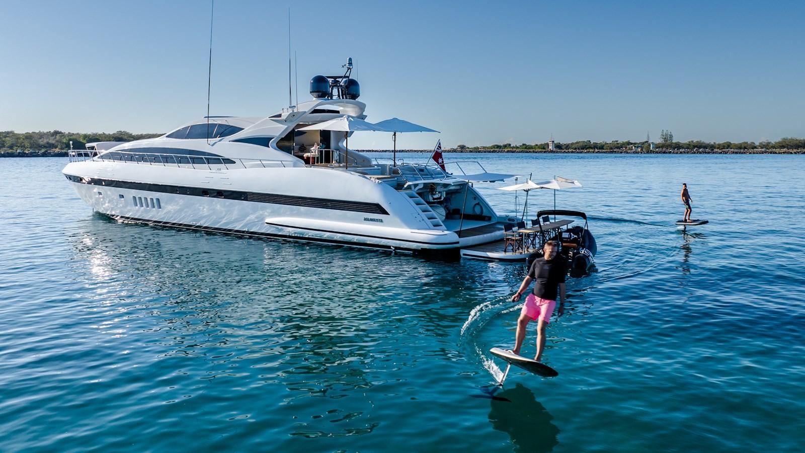 a couple of people on surfboards in the water aboard HELLS BELLS Yacht for Sale