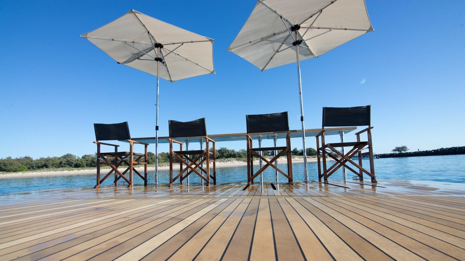 a group of chairs and umbrellas on a dock aboard HELLS BELLS Yacht for Sale