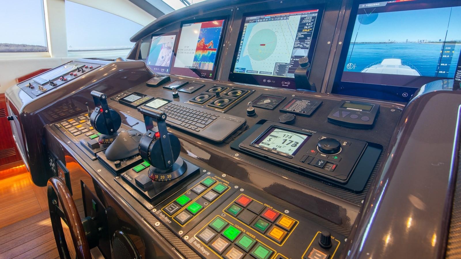 a computer desk with many monitors and keyboards aboard HELLS BELLS Yacht for Sale