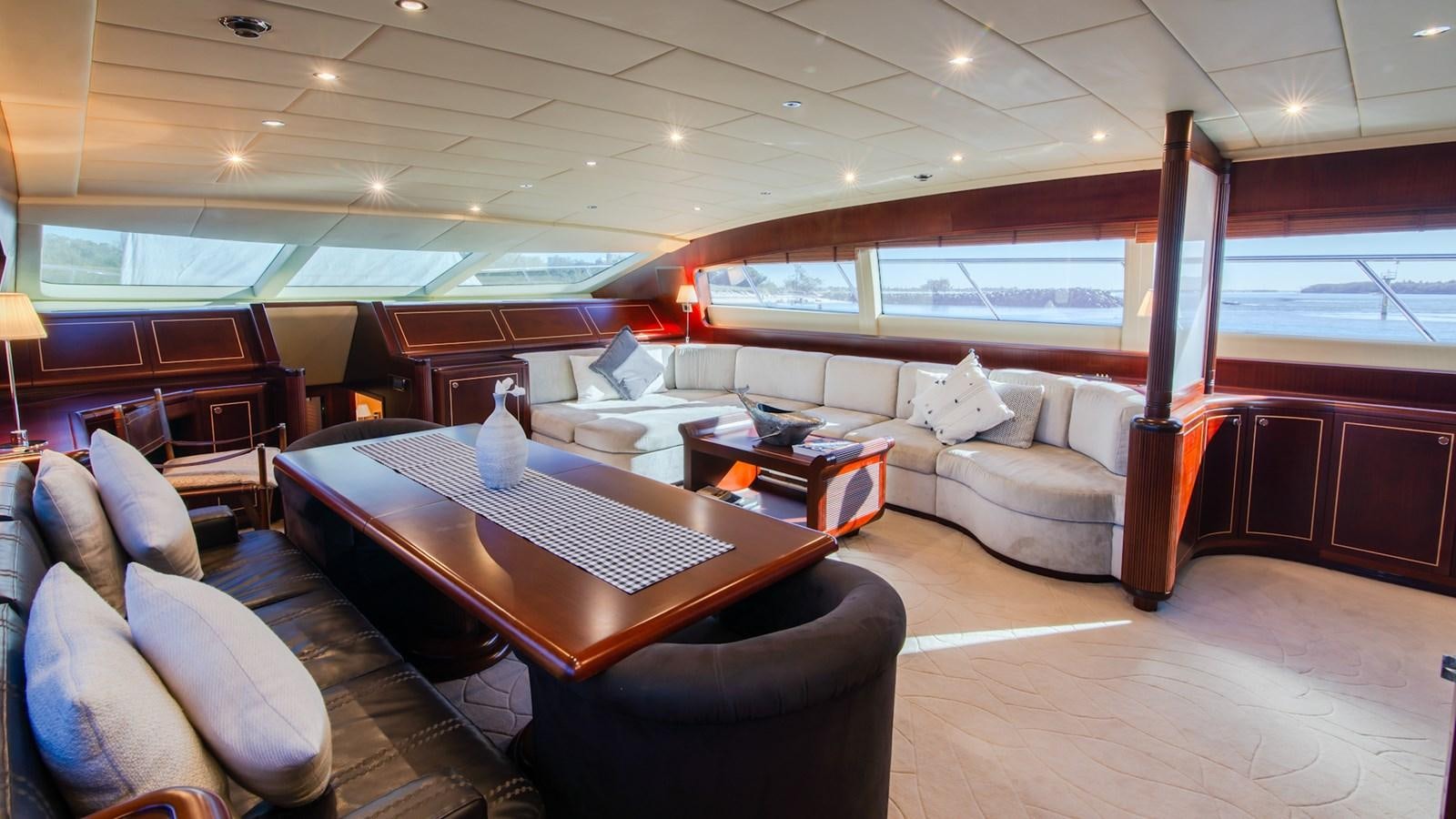 a room with a table and couches aboard HELLS BELLS Yacht for Sale