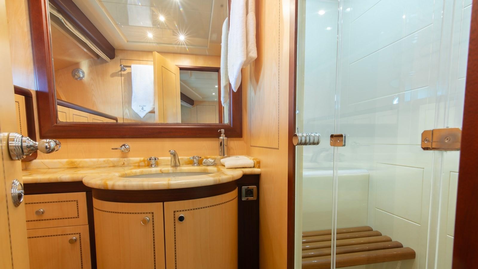 a bathroom with a glass shower door aboard HELLS BELLS Yacht for Sale