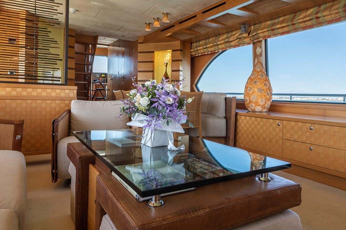 a vase of flowers on a coffee table aboard CIAO Yacht for Sale