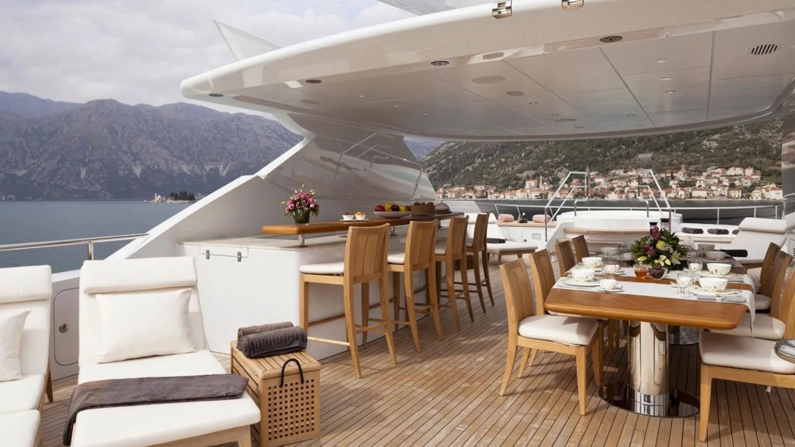 a room with a table chairs and a view of a city aboard ELENA Yacht for Sale