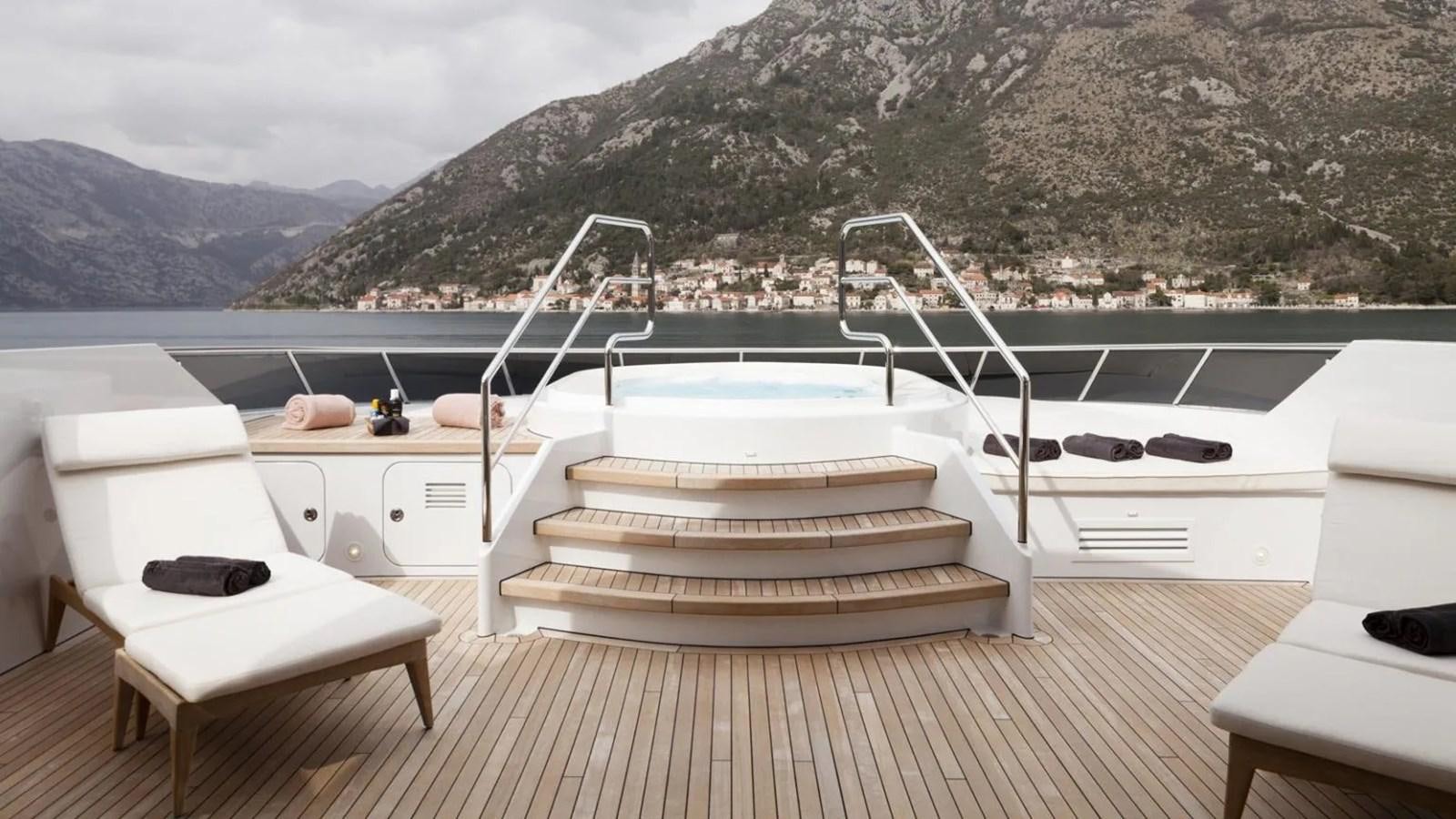 a deck with a view of mountains and water aboard ELENA Yacht for Sale