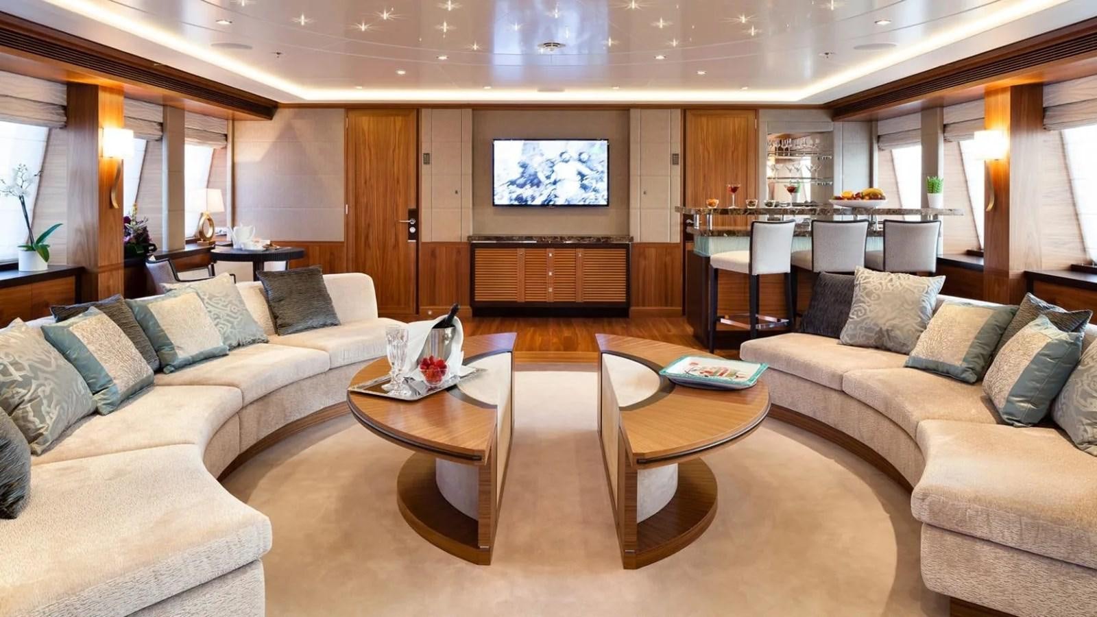 a living room with a table and couches aboard ELENA Yacht for Sale