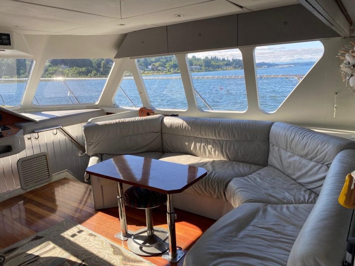a couch with a table in a room with a window aboard AWESOME Yacht for Sale
