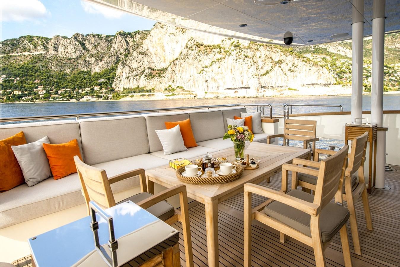 a table with chairs and a couch aboard TIAMAT Yacht for Sale