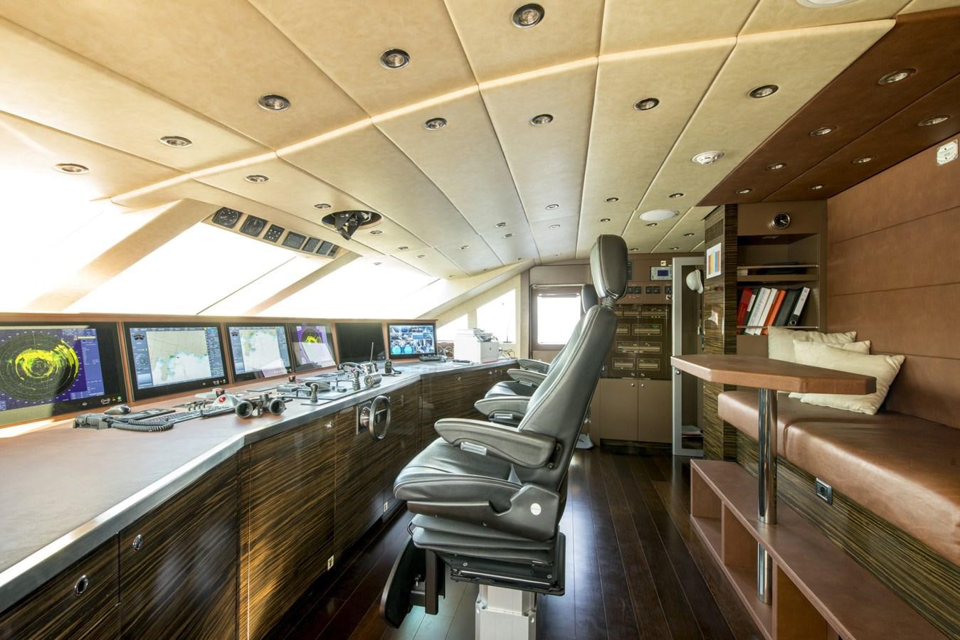 a room with a row of seats and tables with screens and chairs aboard TIAMAT Yacht for Sale