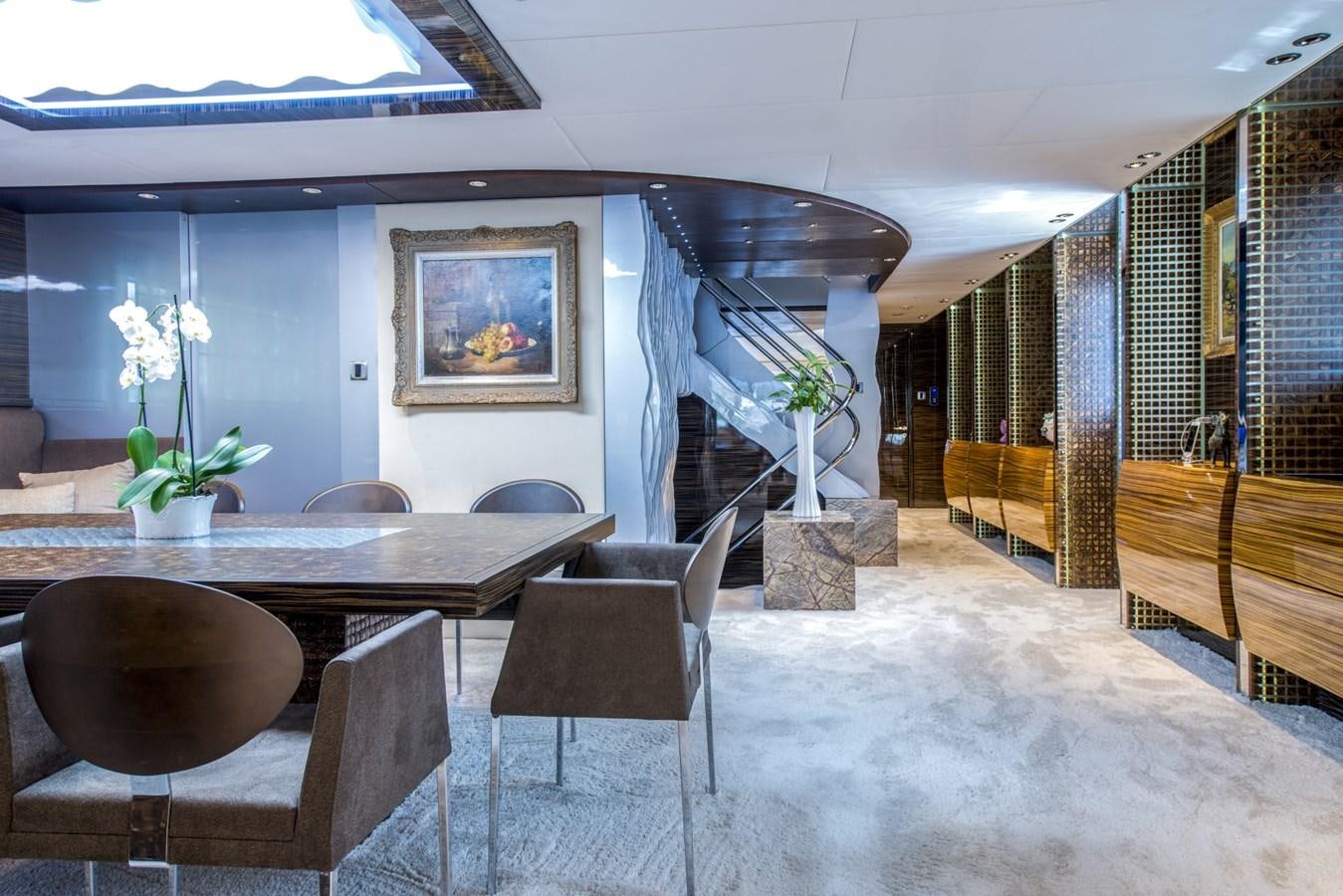 a room with a table chairs and a staircase aboard TIAMAT Yacht for Sale