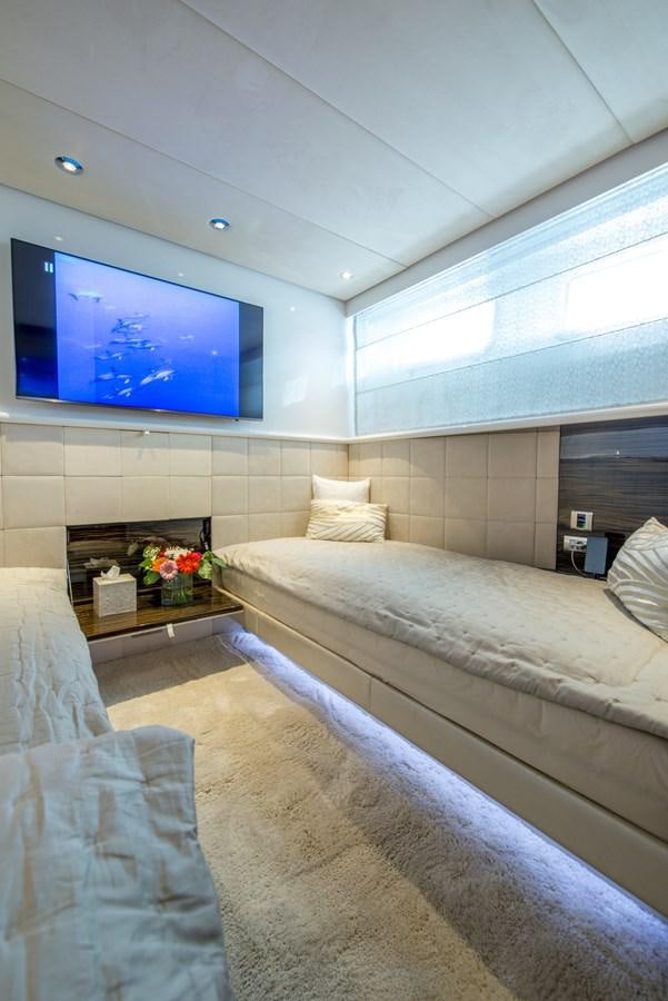 a room with a bed and a tv on the wall aboard TIAMAT Yacht for Sale