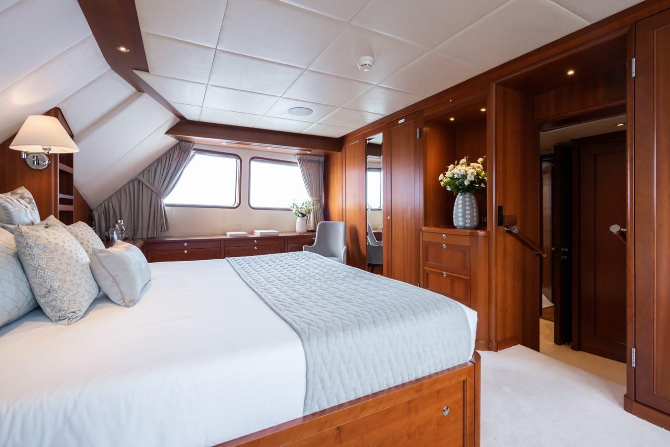 a bedroom with a bed and a desk aboard CORNELIA Yacht for Sale