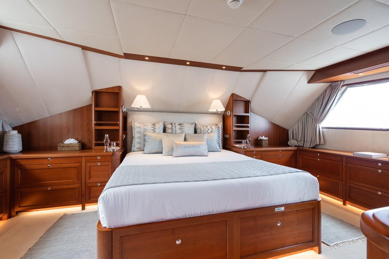a bedroom with a bed and a bookcase aboard CORNELIA Yacht for Sale