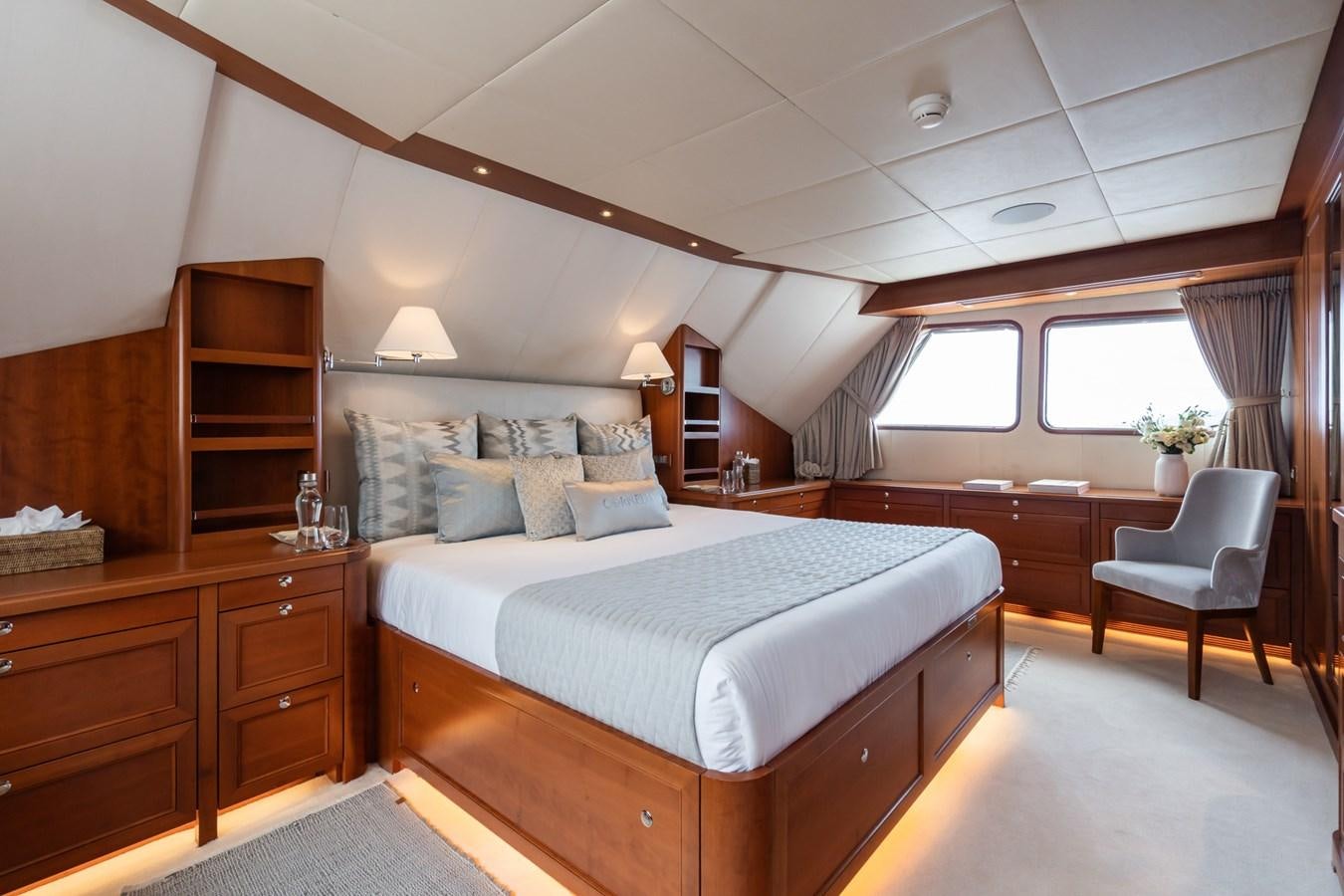 a bedroom with a bed and a chair aboard CORNELIA Yacht for Sale